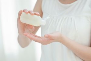 夏の朝にスキンケアをする女性